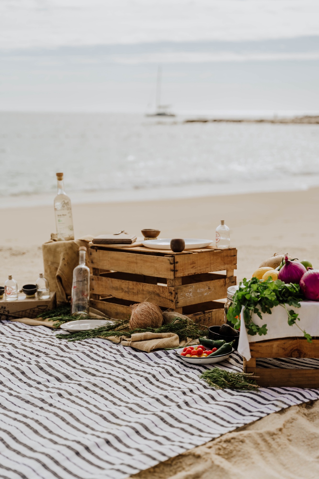 Mesa junto al mar preparada para compartir Todo Bien Mezcal con alimentos y jícaras